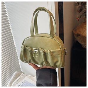 Detail of light green PU leather handbag featuring unique pleated design and silver drawstring