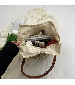 Top view of woven straw tote bag interior with brown leather straps and spacious storage
