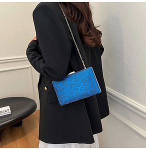 Dettaglio della borsa leopardata blu con catena d'argento indossata da una modella