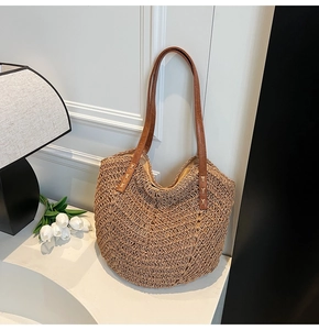 Détail du sac cabas en paille tissée avec anses en cuir marron et texture tressée ajourée
