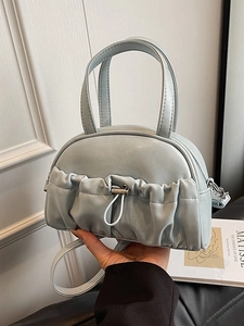 Modern light blue pleated pillow bag with drawstring detail and dual top handles