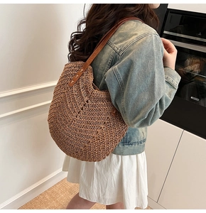 Détail d'un grand sac cabas tissé avec des bandoulières en cuir marron pour la mode