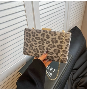 Dettaglio pochette da sera leopardata con catena dorata e chiusura metallica