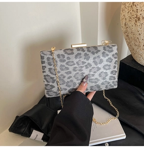 Dettaglio della borsa a mano con stampa leopardata grigia, catena dorata e chiusura