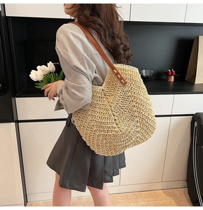 Détail du grand sac cabas en paille tissée avec bandoulière en cuir et coutures blanches