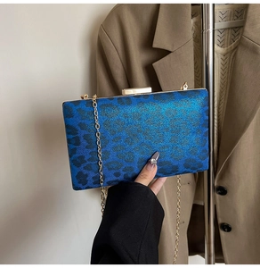 Dettaglio pochette da sera blu leopardata con chiusura dorata e tracolla a catena