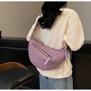 Rear view of a lavender crescent crossbody bag showing its large capacity and woven zipper
