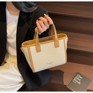 Detailed close-up of woven bucket bag texture with brown leather trim and chic handle