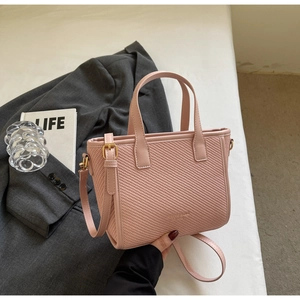Pink woven leather tote bag detailed with cross-pattern texture and gold hardware accents