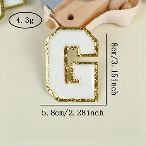 Detailed view of white chenille letter G patch with gold glitter edge and 8cm dimensions