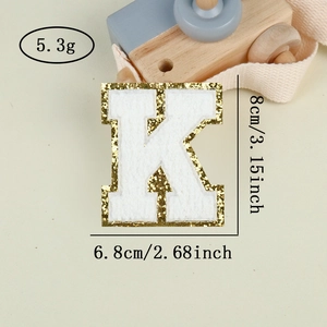 Detailed view of white chenille letter K patch with gold glitter border and dimensions