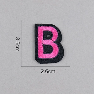 Détail de l'écusson brodé lettre B rose avec bordure noire, dimensions 3,6x2,6 cm