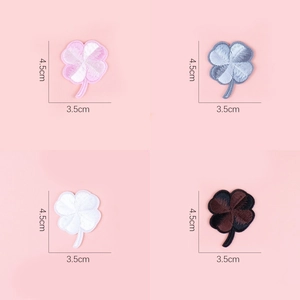 Macro shot of four-leaf clover embroidered patches showing detailed stitching and textures