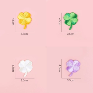 Macro shot of 4.5cm embroidered four-leaf clover patches in yellow, green, white and purple