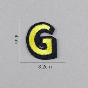 Vue détaillée de l'écusson brodé lettre G jaune avec dimensions de 4cm par 3,2cm