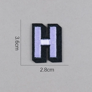 Détail de l'écusson brodé lettre H violet et noir avec mesure de hauteur de 3,6 cm