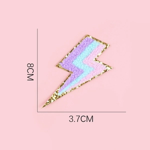Detail showing 8cm lightning bolt embroidery patch with pink blue purple stripes and gold sequins