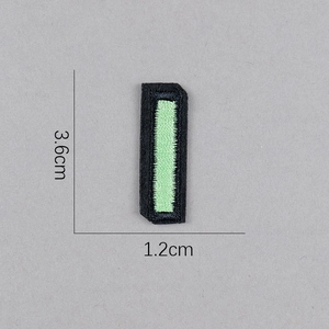 Détail d'un écusson brodé rectangulaire de 3,6x1,2 cm avec bordure noire et centre vert