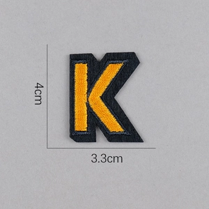 Détail de l'écusson brodé lettre K jaune de 4cm de haut avec support en feutre noir
