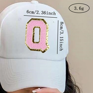Detail of chenille letter Q patch with gold sequins on white baseball cap
