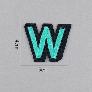 Détail de l'écusson brodé lettre W cyan sur feutre noir avec dimensions de 5cm par 4cm