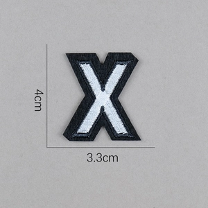 Détail macro de l'écusson brodé lettre X noir et blanc avec mesure de 4 cm de hauteur