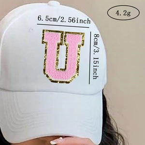 Detail of pink chenille letter U patch with gold sequins on white baseball cap
