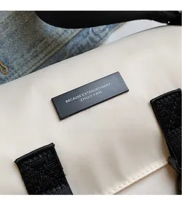Detailed macro view of the nylon messenger bag buckle and textured strap attachment