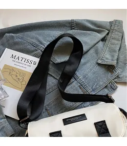 Detail of adjustable black nylon shoulder strap on off-white messenger bag with logo
