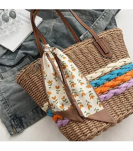 Dettaglio borsa shopper in paglia intrecciata con strisce colorate e foulard sul manico