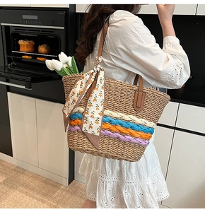 Dettaglio borsa shopper in paglia intrecciata con strisce colorate e foulard con fiori