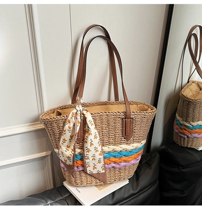 Dettaglio borsa tote in paglia con fasce intrecciate colorate e sciarpa di seta decorativa