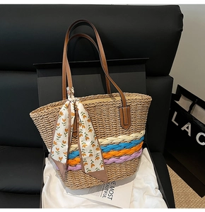 Dettaglio borsa di paglia con strisce colorate e foulard in una confezione regalo