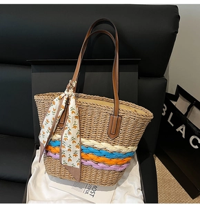 Dettaglio borsa tote in paglia con base intrecciata colorata, manici in pelle e foulard