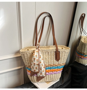 Dettaglio borsa di paglia con strisce colorate, tracolla in pelle e foulard a fiori