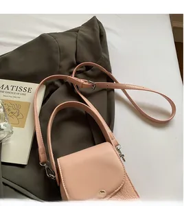 Detail of pink crossbody bag with adjustable strap and silver magnetic closure