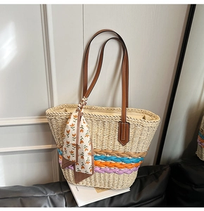 Dettaglio borsa in paglia con strisce colorate, manici in pelle e foulard di seta