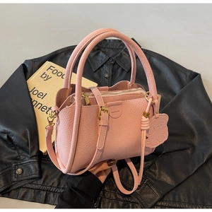 Detailed close-up of pink bucket bag featuring lychee grain texture and cloud charm
