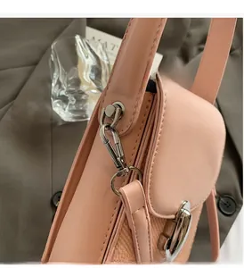 Detailed shot of pink leather woven bag with glossy silver metal hardware and buckle