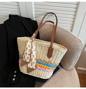 Dettaglio della borsa tote in paglia intrecciata con finiture colorate e manici