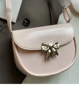Close-up of semi-circle saddle bag with silver bow buckle and soft pink PU leather