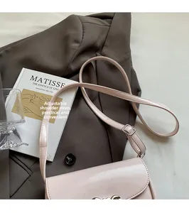 Detail of adjustable shoulder strap on a light pink leather crossbody saddle bag
