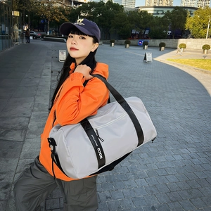 Sac de sport cylindrique gris clair imperméable porté par une personne dehors
