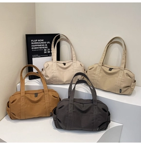 Macro shot of canvas duffle bags in cream, khaki, brown, and grey on geometric stands