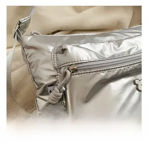 Detailed macro of silver metallic quilted bag with zipper and bear logo accent