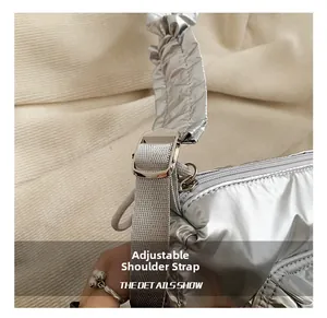 Detail of adjustable nylon strap and silver buckle on metallic drawstring shoulder bag