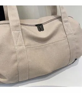 Detailed close-up of beige canvas travel bag featuring durable dual metal zippers