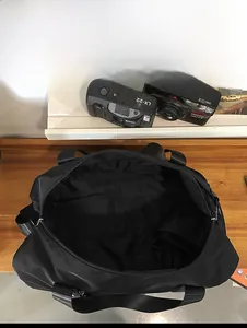 Vue de dessus du grand sac de voyage noir montrant l'intérieur spacieux sur bois
