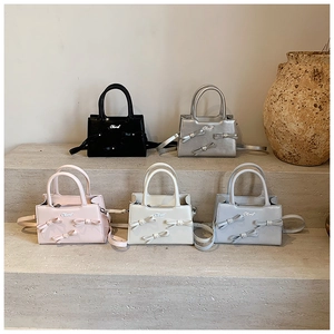 Multiple views of mini bow crossbody bags in five colors with metallic finish and handles