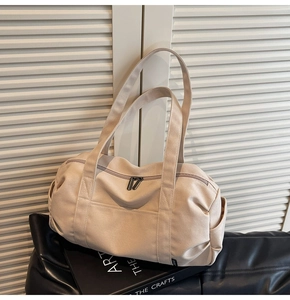 Detail of beige canvas travel bag with dual straps and zipper on minimalist background
